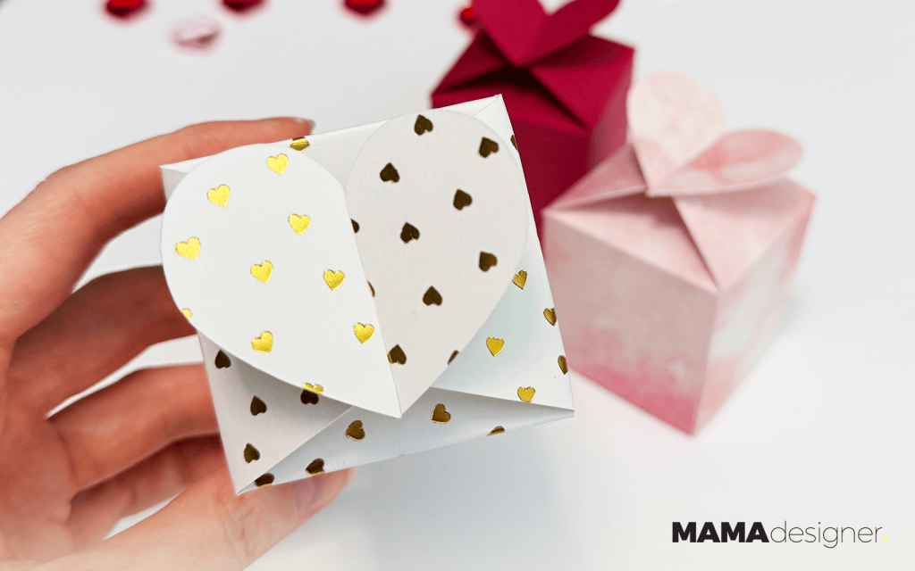 Zbliżenie na białe pudełeczko w złote serduszka.