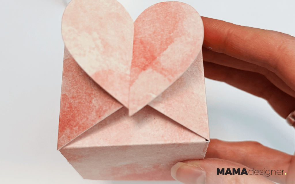 Zbliżenie na różowe pudełeczko z motywem akwarelowym.